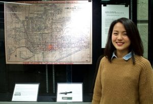 Photo Sakoto Nakamoto in front of library display and map. Photo credit Wes Adams/CTSI